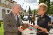 Polizist Mohr (Max Müller, r.) bittet den Lehrer Karlheinz Nebel (Heinz-Josef Braun, l.) um seinen Personalausweis.