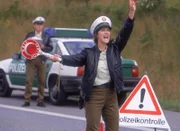 Holzmanns LKW hat die Polizeisperre durchbrochen, die Polizisten Petra (Margrit Sartorius) kann sich in letzter Sekunde durch einen Sprung zur Seite retten...