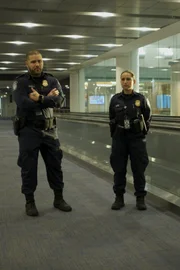 Miami, FL - Officers Adriel and Claudia Pupo stand guard as they await for passengers coming from departing flights.(National Geographic/Lucky 8 TV)