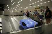 Passagiere stehen um ein Gepäckkarussell an der Gepäckausgabe des John F. Kennedy International Airport. (National Geographic)