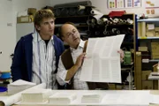 Beim Buchbinder (Uwe Karpa) erfährt Fritz Fuchs (Guido Hammesfahr), wie aus einem großen Bogen Papier die Seiten eines Buches entstehen.