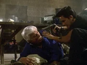 Dr. Mark Sloan (Dick Van Dyke, l.) wird von Ving, dem Anführer der Terroristen, bedroht, weil er nicht bereit ist, seinen Befehlen Folge zu leisten.