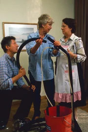 Hannelore (Maria Sebaldt, M.) kämpft mit dem Shamponiergerät. Nachbar Meisel (Siegfried Grönig, l.) und Gerda (Inge Wolffberg, r.) helfen dabei.