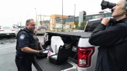 Ein Kameramann filmt den CBP-Beamten Ryan, wie er den Inhalt einer zerbrochenen Styropor-Kühlbox untersucht, die auf der Ladefläche eines Lastwagens gefunden wurde, der über den JFK-Flughafen in New York City, N.Y., verschifft wurde (National Geographic for Disney)