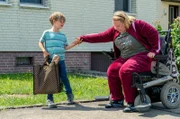 Dustin Schinschke (Franz Schmidt) hilft Diana Pötschke (Hildegard Schroedter) aus dem Rollstuhl.