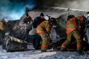 Firefighters (played by background actors) peel the metal frame of Continental Airlines Flight 1713 back.