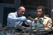 The Lead Namibian Investigator (played by Jamaal Grant) and Investigator Dennis Jones (played by Glen Michael Grant) work together to analyze pieces of wreckage to find out what happened to LAM Mozambique Flight 470. (Cineflix/Pana Pantazidis)