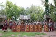 Checker Tobi in Legionärsausrüstung mit den anderen römischen Soldaten vor einem Castrum.