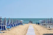 Umbrellas on the beach of Lido di Jesolo at adriatic Sea in a beautiful summer day, Italy.