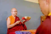 Meditations-Meister Lama Khesang unterrichtet Klangmeditation mit einer Klangschale.