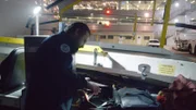 A HSI Officer at JFK looks over suitcase that has white residue. (National Geographic/Lucky 8 TV)