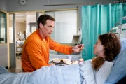 Neiss (Patrick Kalupa) sitzt am Bett von Andrea Wellenbrink (Anja Antonowicz) und füttert sie, da sie ihre Arme nicht bewegen kann.