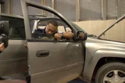 Ein Kameramann filmt den CBP-Beamten Williams, wie er die Tür des Fahrzeugs eines Verdächtigen auf der Suche nach weiteren versteckten Schmuggelwaren in Calexico, Kalifornien, aufbricht (National Geographic for Disney).