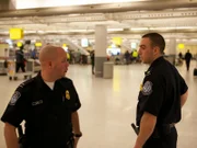 U.S. Customs and Border Protection Officers Chris Elias and Joe Finn discuss a case unfolding at John F. Kennedy International Airport.