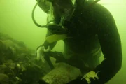 Scott Meisterheim digs in murky water.