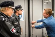 Oskar Politz (Jürg Plüss, r.) zeigt Melanie (Sanna Englund, l.) und Mattes (Matthias Schloo, M.), dass die Türen des Kühlcontainers nicht von allein zugefallen sein können. Es muss jemand absichtlich seinen Kollegen darin eingesperrt haben.