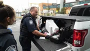 CBP-Beamter Knox sieht zu, wie CBP-Beamter Ryan den Inhalt einer zerbrochenen Styropor-Kühlbox untersucht, die auf der Ladefläche eines Lastwagens gefunden wurde, der über den JFK-Flughafen in New York City, N.Y., verschifft wurde (National Geographic for Disney)
