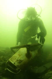 Diver digs in murky water.
