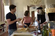 Beim gemeinsamen Kochen schimpft Gilbert (Tony de Maeyer, r.) gegenüber André (Bruno Bruni, l.) und Emilie (Mathilde Irrmann, M.) auf Charlotte.
