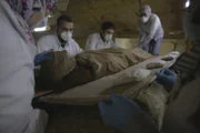 Die in ein schützendes Leichentuch gehüllte Mumie von Tadihor wird behutsam auf ein Brett gelegt, um ihre Überreste für die Röntgenaufnahme vorzubereiten. Dieses nächste Kapitel in Tadihors Geschichte sollte noch mehr Hinweise auf ihre lange vergessene Identität liefern.