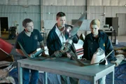 NTSB-Ermittler Jeff Guzzetti (gespielt von Sergio Di Zio) und andere NTSB-Ermittler (gespielt von Schauspielern im Hintergrund) untersuchen die verbogenen Propellerblätter des Flugzeugwracks von John F. Kennedy Jr.