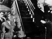 Sir Wilfrid Robarts (Charles Laughton, r.) hat die Verteitigung von Leonard Vole übernommen, obwohl sein Gesundheitszustand das eigentlich nicht zulässt. Jetzt lernen er und sein Partner Brogan-Moore (John Williams, l.) die Frau ihres Mandanten kennen. Christine Vole (Marlene Dietrich) irritiert sie sehr.