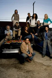 Los Angeles, California: Cast members of the Colony, l-r: John Cohn, Amy West, Joey Sciacca, Mike Raines, Morgan Hooker, Lelaini Smith, Vladimir Beck, John Valencia (squatting, front), Alison White, George Fallieras, on wrecked cars in the car park area of the set, Los Angeles, California. 3/5/2009 (Photo: Ann Summa/Getty Images).