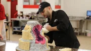 Ralph places rice krispies around the cake layers to give it stability and shape.