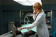 Rechtsmedizin – Dr. Schmidt (Helene Grass) telefoniert und nimmt nebenbei die Leiche oberflächlich in Augenschein.