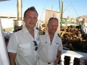 Von links: Deck-Kadett Christian Baumann und Kapitän Morten Hansen besichtigen ein Dau-Boot in Salalah, Oman.