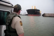 Brownsville, TX, USA: A U.S. Border Patrol agent watches a tanker move in the harbor.