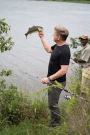 KwaZulu-Natal, South Africa - Gordon Ramsay (L) fishing in KwaZulu-Natal, South Africa with Lonely (R), a local wildlife expert. (Credit: National Geographic/Justin Mandel)
