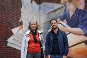 Mirko Drotschmann mit der Künstlerin Hildegund Schuster vor dem Wandbild der Kaffeeverleserin