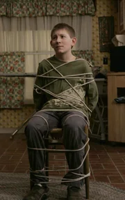 Um keinen Blödsinn zu machen, wird Dewey (Erik Per Sullivan) von seinen Brüdern an einen Stuhl gefesselt ...