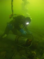 Scuba diver with underwater dredger.