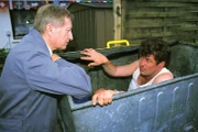 Pröter (Wilfried Herbst, l.) überrascht Benno (Willi Thomczyk) beim Suchen seines alten Trainingsanzugs in der Mülltonne.