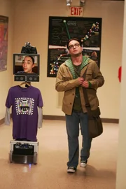 Sheldon (Jim Parsons, l.) hat ein mobiles Gerät entworfen, mit dem er per Kamera, Mikro und Lautsprecher über einen Monitor mit den anderen kommunizieren kann, während er sein Bett nicht mehr verlassen muss. Leonard (Johnny Galecki, r.) ist von der Situation zunehmend genervt.