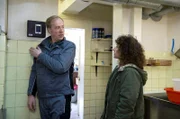 Harry (Maria Ketikidou, r.) befragt den Sicherheitstechniker Ronnie Oswald (Stefan Leonard, l.), der die Sicherheitstechnik in die Hutmacherei eingebaut hat.