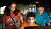 Leo (Charlotte Farhadi), Hakim (Mads Albatros) und Moritz (Jan Friedrichsen) fragen sich, was Amy am Computer recherchiert haben könnte.