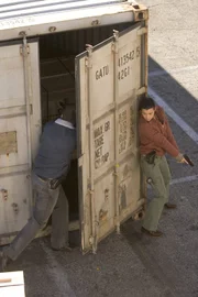 Ziva (Cote de Pablo, r.) und Tony (Michael Weatherly, l.) sind am Hafen von Norfolk. Sie laufen zwischen Containern umher, als plötzlich auf sie geschossen wird. Sie nehmen in einem offen stehenden Container Deckung, doch dann wird die Tür zu geschlagen und sie sitzen fest ...