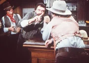 Mr. Edwards (Victor French, M.) misst sich im Saloon beim Armdrücken.