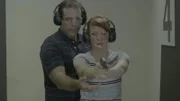 A man trains a woman to shoot