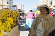 Eine Bananenhändlerin sitzt auf den Schienen in Puno: Die Durchfahrt jedes Zuges wird von einem vorausfahrenden Sicherheitsfahrzeug angekündigt, damit die Schienen geräumt werden.
