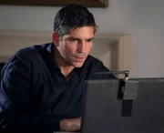 Reese (Jim Caviezel) überwacht die Webcams in dem Gebäude, um Finch bei seiner Spurensuche Deckung zu geben.