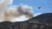 A fire helicopter prepares to make a water drop over the Tehachapi fire.