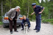 Nachdem der Trüffelhund des Verstorbenen herrenlos durch den Walt gelaufen ist, nehmen sich Kommissar Stadler (Dieter Fischer, l.), Polizeihauptmeister Mohr (Max Müller, M.) und dessen Kollege seiner an.