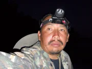 Nachts, auf der Suche nach dem großen Kaiman, Nahaufnahme Gesicht vom Yung Sandy, mit Kopflampe.