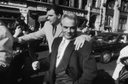 8. Februar 1990: Der US-amerikanische Mafiaboss John Gotti (1940 - 2002) verlässt das Gericht mit seinen Anwälten während einer Verhandlungspause wegen der Entscheidung der Jury in New York City. Ein Mann hat seinen Arm auf Gottis Schulter.