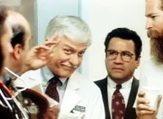 Dr. Sloan (Dick Van Dyke, M. l.) wird zu Normans (Michael Tucci, M. r.) Entsetzen von einer Filmcrew als Schauspieler engagiert._Titel: Diagnose: Mord