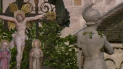 Symbolbild Detail Römerstatue und Kruzifix im Friedhof St. Peter in Salzburg.